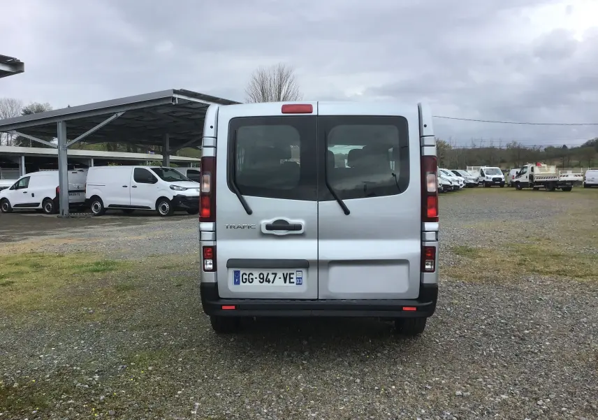 Vue arrière d'un Renault Trafic Combi gris clair métal 2022, avec portes battantes et vitres teintées.