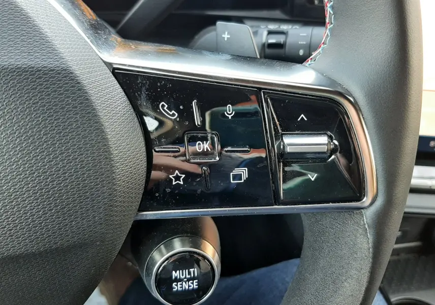 Gros plan sur le côté gauche du volant noir du Renault Austral 2025, avec commandes tactiles et bouton Multi Sense.