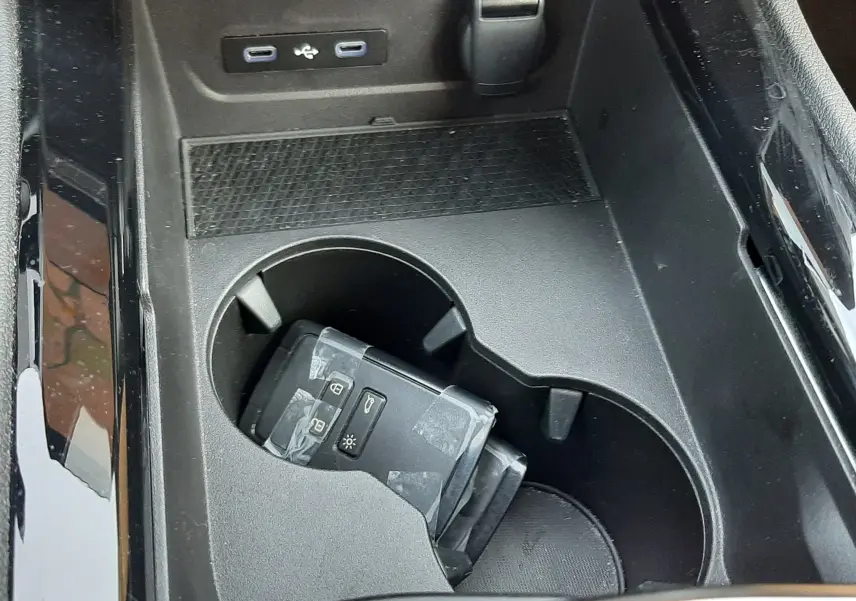 Gros plan sur la console centrale noire du Renault Austral 2025 avec porte-clés et ports USB visibles.