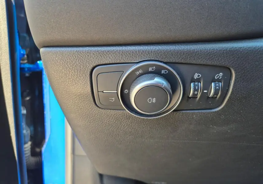 Gros plan sur le bouton de commande des feux dans l’habitacle d’une Alfa Romeo Tonale bleu 2025.