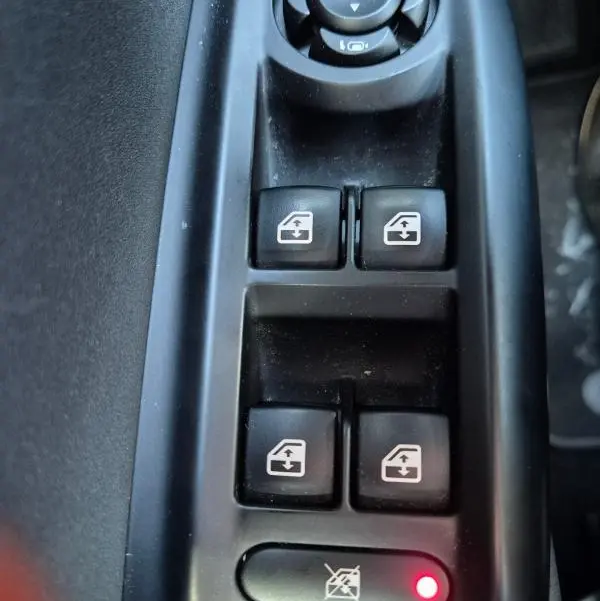 Gros plan sur les commandes de lève-vitres et rétroviseurs électriques dans l'habitacle noir de l'Alfa Romeo Tonale 2025.