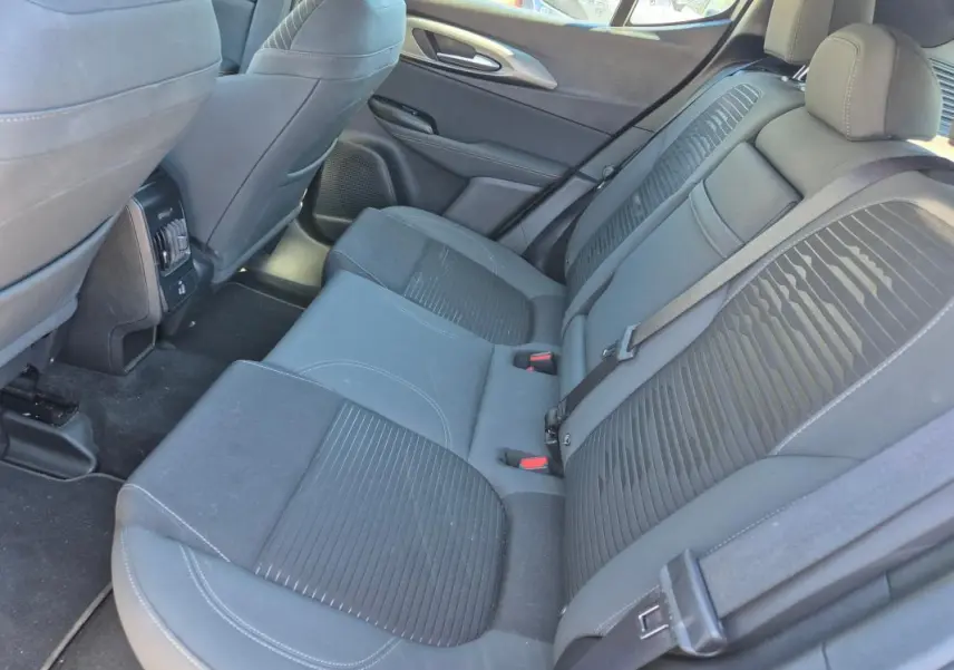 Vue intérieure arrière des sièges en tissu gris foncé de l'Alfa Romeo Tonale 2025, avec ceintures de sécurité visibles.