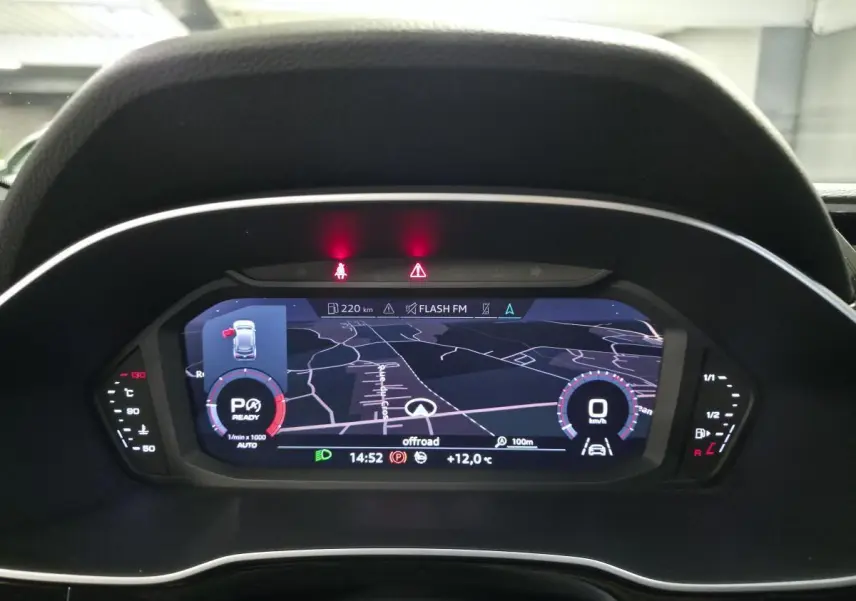 Vue rapprochée du tableau de bord numérique de l'Audi Q3 2019, affichant la navigation et les indicateurs de conduite.