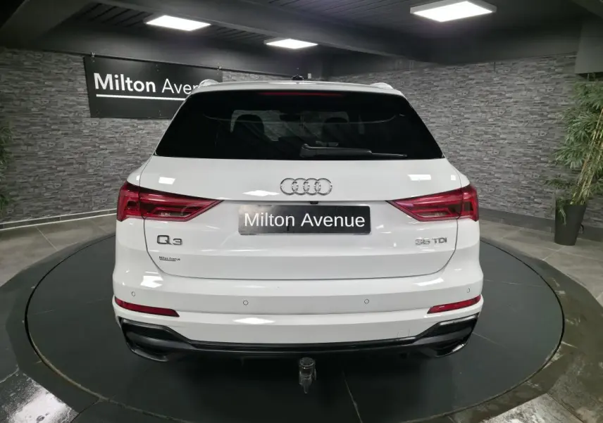 Vue arrière d’un Audi Q3 blanc 2019 avec hayon électrique et crochet d’attelage dans un showroom.