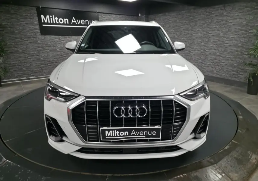 Vue avant d'un Audi Q3 blanc S-Line 2019 avec calandre noire et logo Audi bien visible.
