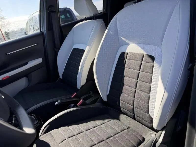 Vue intérieure rapprochée des sièges avant en tissu noir et clair de la Citroën C3 1.2 Turbo 100ch MAX, 2025.