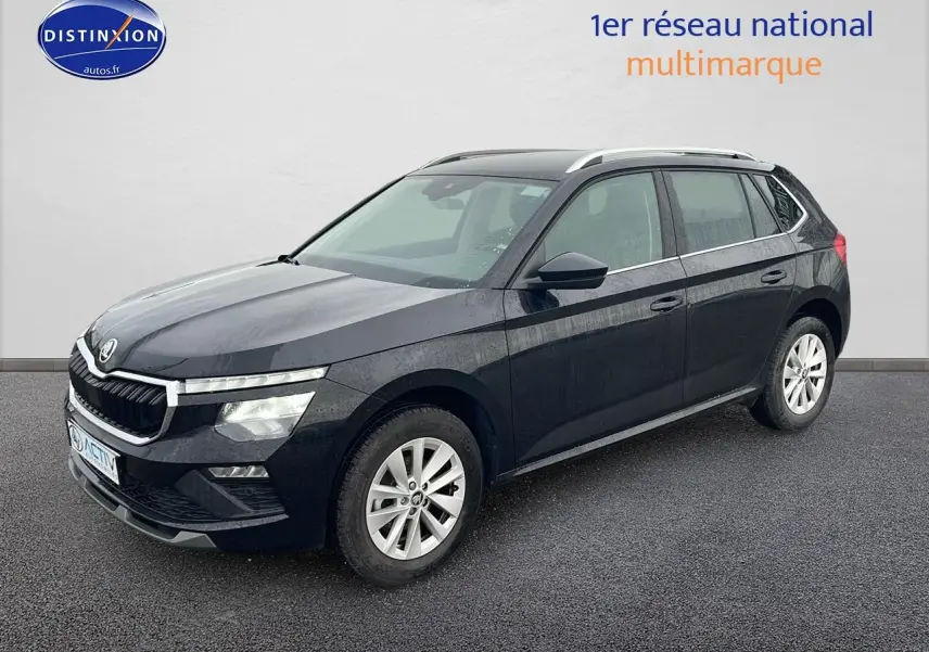 Vue 3/4 avant d’un Skoda Kamiq noir 2025 avec jantes alu et barres de toit argentées sur fond neutre.