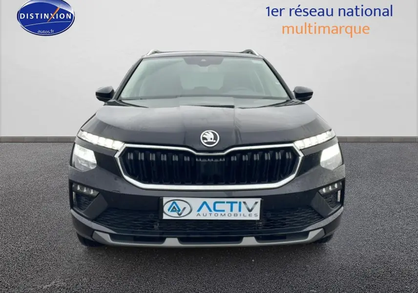 Vue avant d'un Skoda Kamiq noir 2025 avec calandre chromée et feux LED allumés.