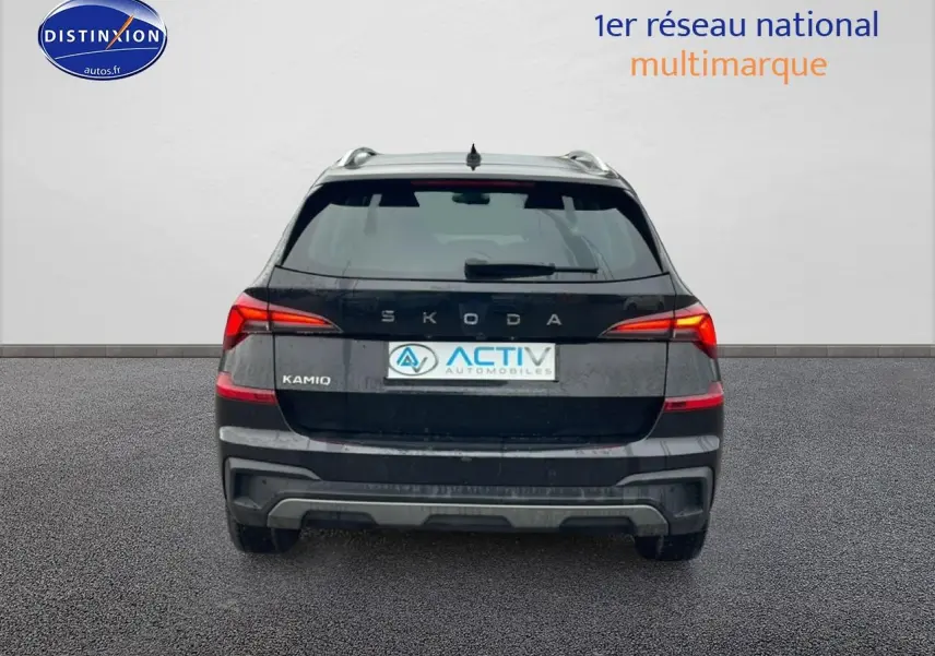 Vue arrière d'un Skoda Kamiq noir 2025 avec feux LED et barres de toit visibles sur fond neutre.