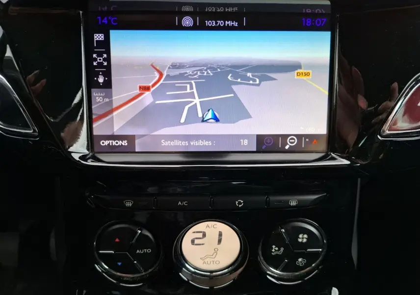 Vue rapprochée du tableau de bord de la Citroën DS3 gris clair 2015, mettant en valeur l’écran GPS et la climatisation automatique.