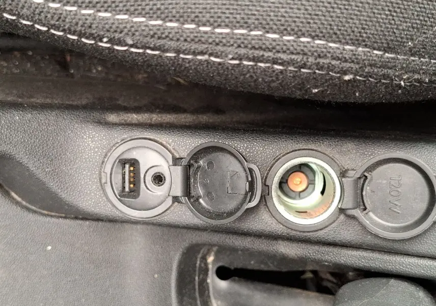 Gros plan sur la prise USB et l’allume-cigare dans l’habitacle noir d’une Citroën DS3 gris clair.