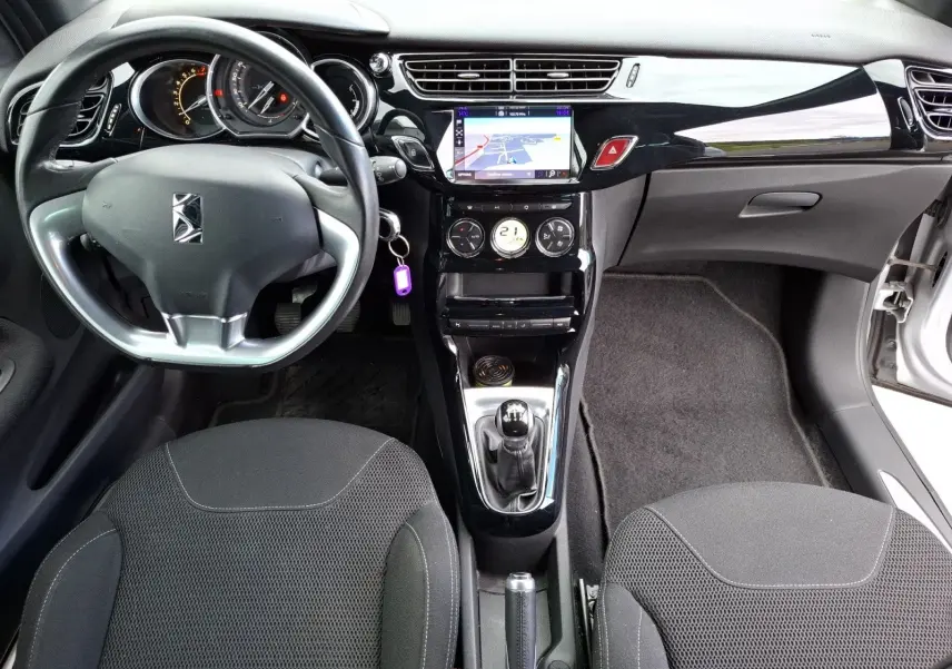 Vue intérieure avant de la Citroën DS3 1.2 PureTech 110 so chic avec tableau de bord noir brillant et écran GPS tactile.