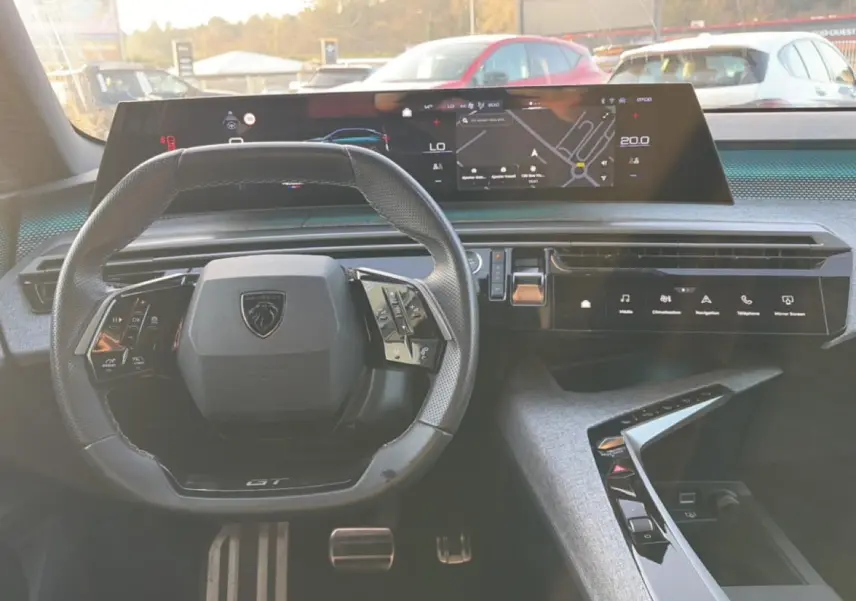 Vue intérieure centrée sur le volant cuir multifonction et l'écran tactile large du tableau de bord du Peugeot 3008 gris.