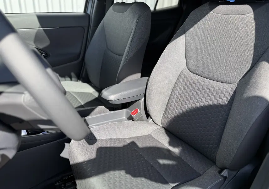 Gros plan sur les sièges avant en tissu gris du Toyota Yaris Cross 1.5 Hybrid 130ch, intérieur lumineux et moderne.