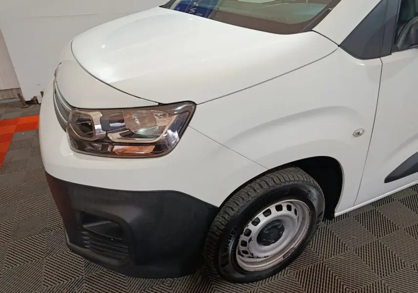 Vue 3/4 avant droit du Citroën Berlingo blanc avec pare-chocs noir et jante acier simple.