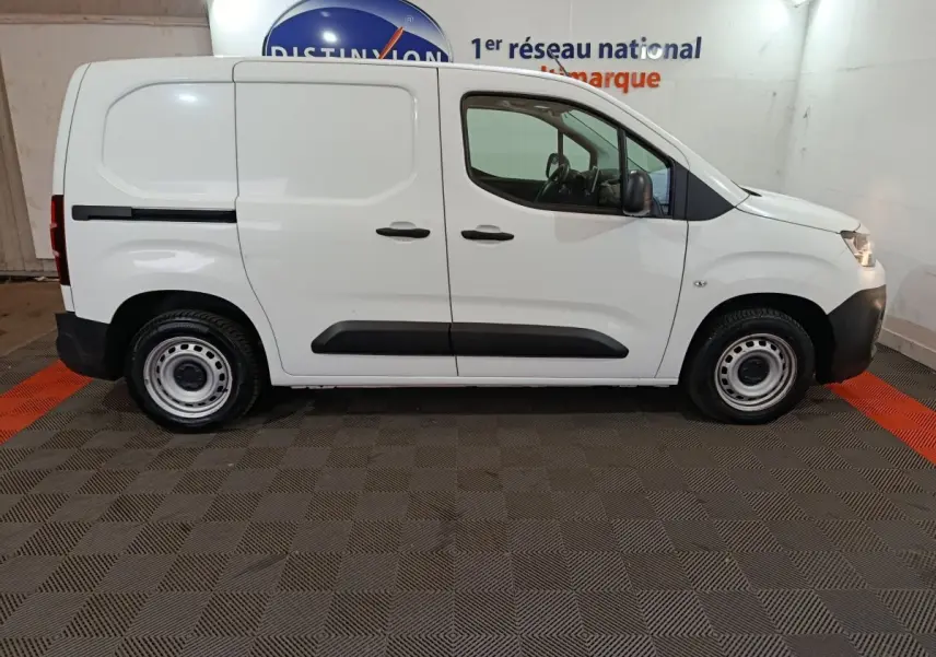 Vue de profil côté droit d’un utilitaire Citroën Berlingo blanc avec jantes acier et portes latérales pleines.