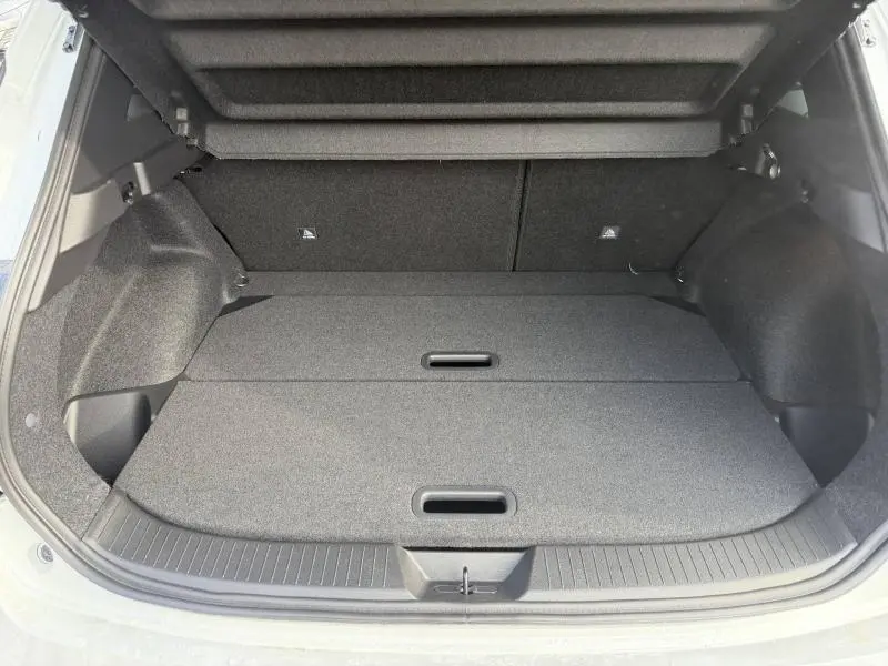 Vue intérieure du coffre ouvert du Nissan Qashqai Hybrid e-POWER blanc nacré, montrant un espace de rangement plat et spacieux.