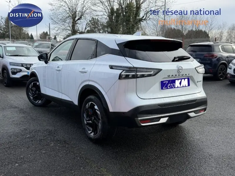 Vue 3/4 arrière droite du Nissan Qashqai Hybrid e-POWER blanc nacré avec jantes noires et détails noirs contrastants.