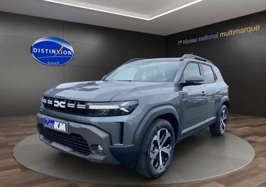 SUV Dacia Duster Journey Hybrid 140 gris foncé vu en 3/4 avant droit avec calandre et phares LED distinctifs.