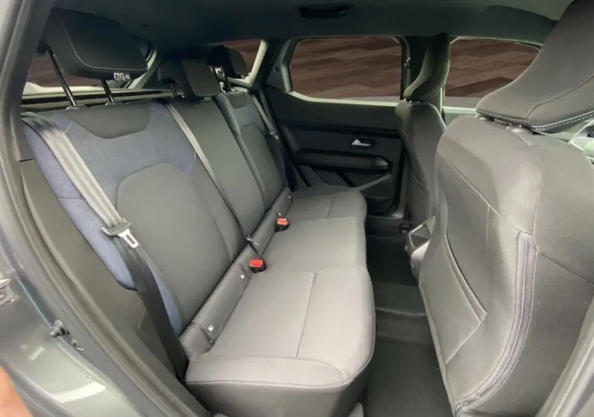 Vue intérieure côté droit sur la banquette arrière grise du Dacia Duster Journey Hybrid 140 2025.