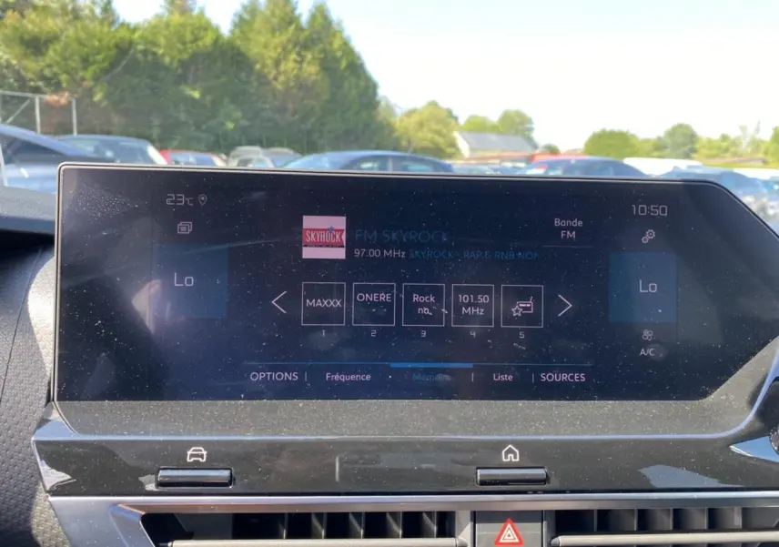 Écran tactile central du tableau de bord de la Citroën C4 2021, affichant la radio FM Skyrock en extérieur lumineux.