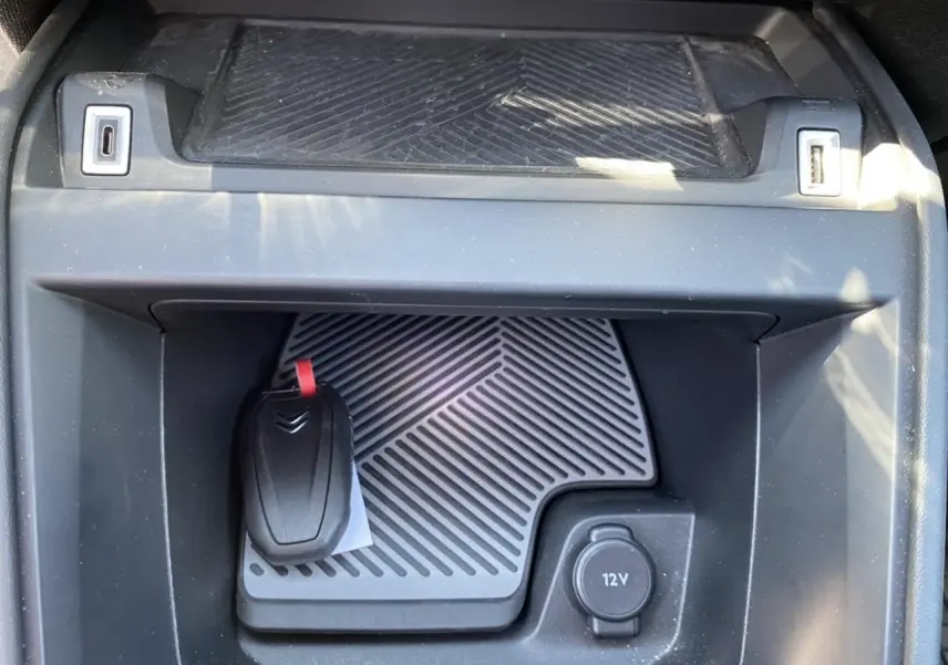 Gros plan sur la console centrale d’une Citroën C4 gris foncé 2021, avec clé et prise 12V visibles.