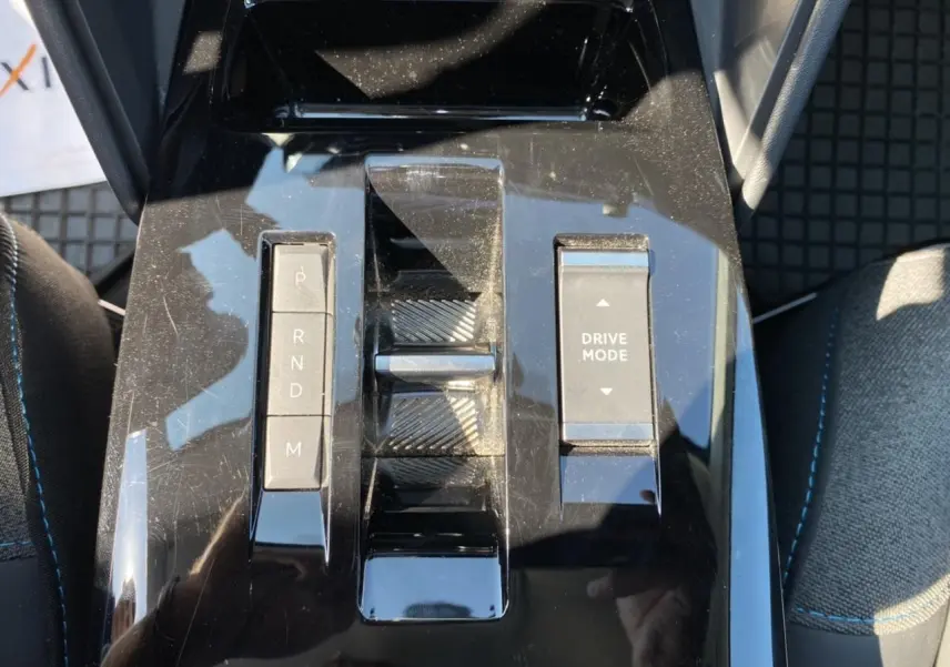 Gros plan sur la console centrale noire brillante de la Citroën C4 2021 avec commandes de boîte auto et mode de conduite.