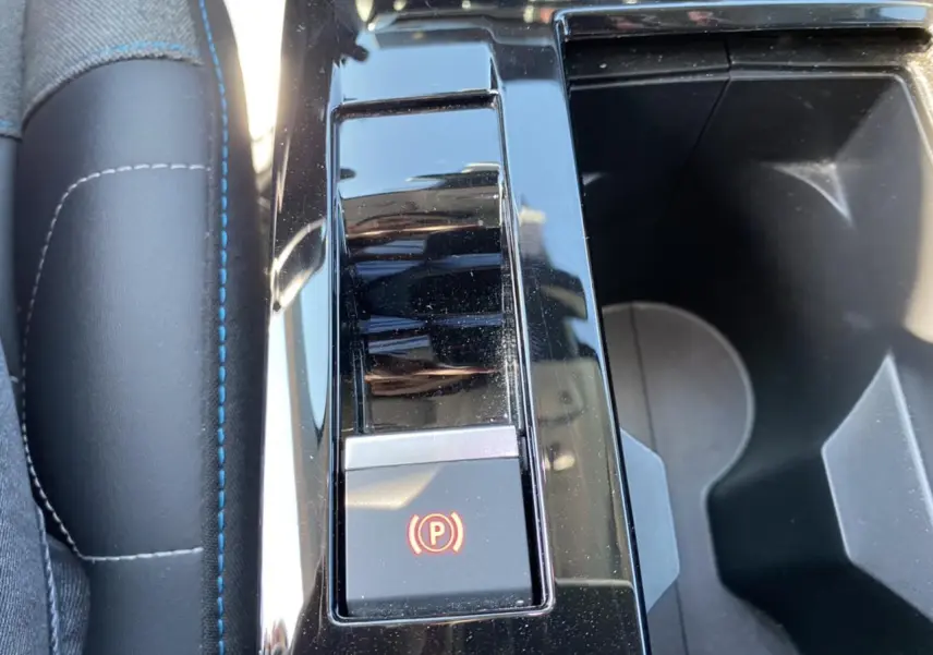 Gros plan sur la console centrale du Citroën C4 gris foncé 2021, mettant en valeur le frein à main électronique.