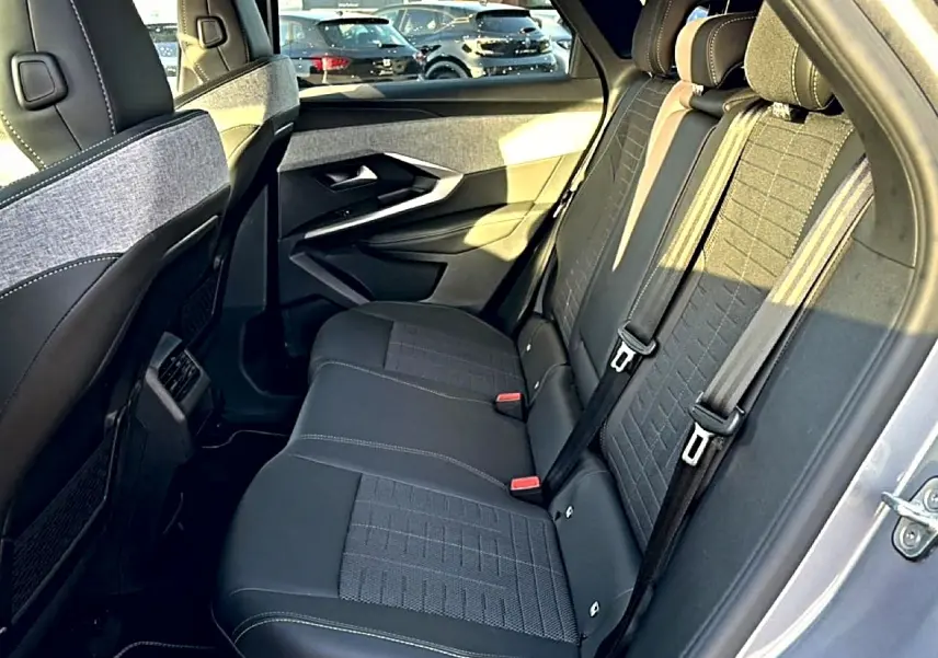 Vue côté droit de la banquette arrière grise du Peugeot 3008 1.2 hybrid 145 GT, avec ceintures de sécurité visibles.