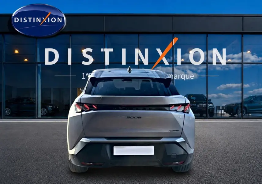 Vue arrière d'un Peugeot 3008 gris 2025 avec feux LED distinctifs, garé devant une vitrine Distinxion.