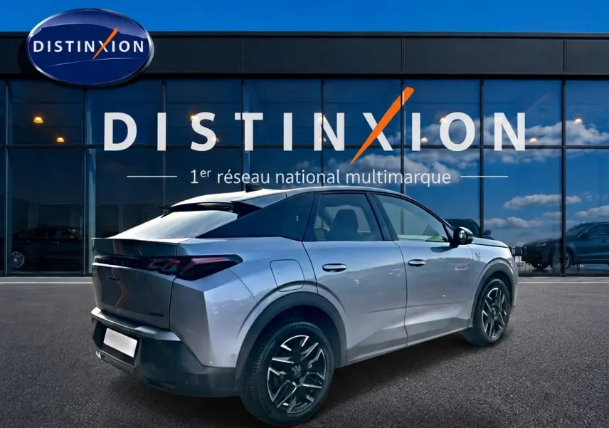 Peugeot 3008 gris en 3/4 arrière droit, avec jantes alu noires et toit noir contrasté, devant showroom Distinxion.