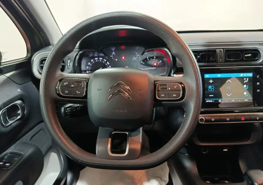 Vue intérieure centrée sur le volant multifonctions noir de la Citroën C3 2024 avec tableau de bord et écran tactile visible.