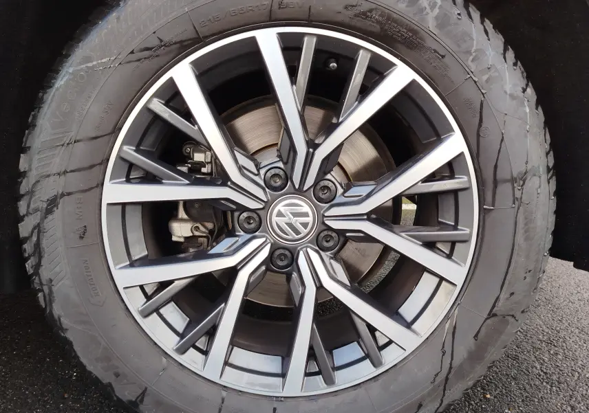 Gros plan sur la jante alliage bicolore du Volkswagen Tiguan noir intense nacré, mettant en valeur le logo central VW.