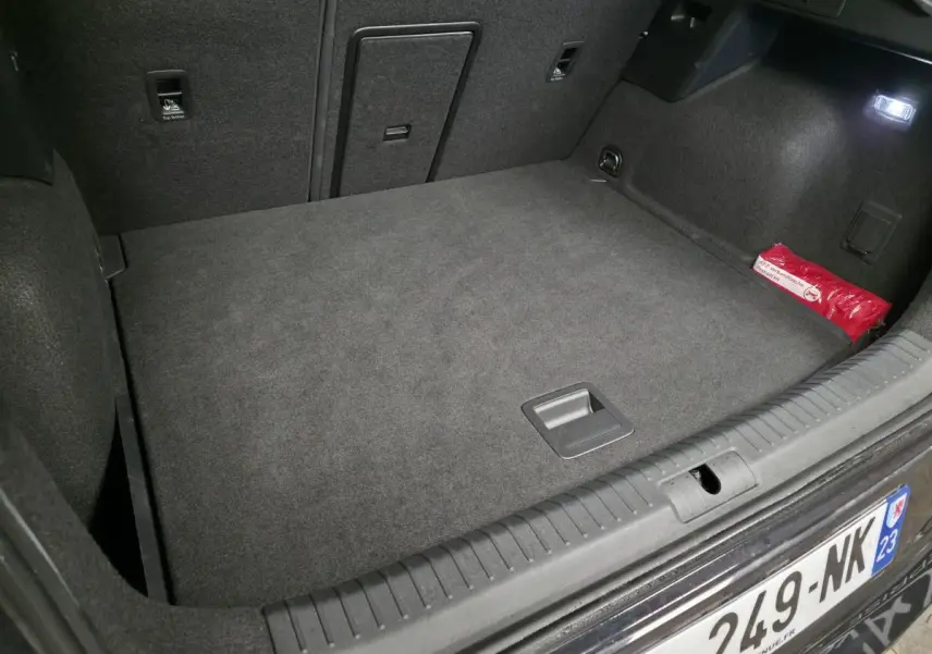 Vue intérieure du coffre spacieux et tapissé en gris foncé du CUPRA Formentor 2.0 TDI 2025, avec trappe centrale et kit de secours rouge.