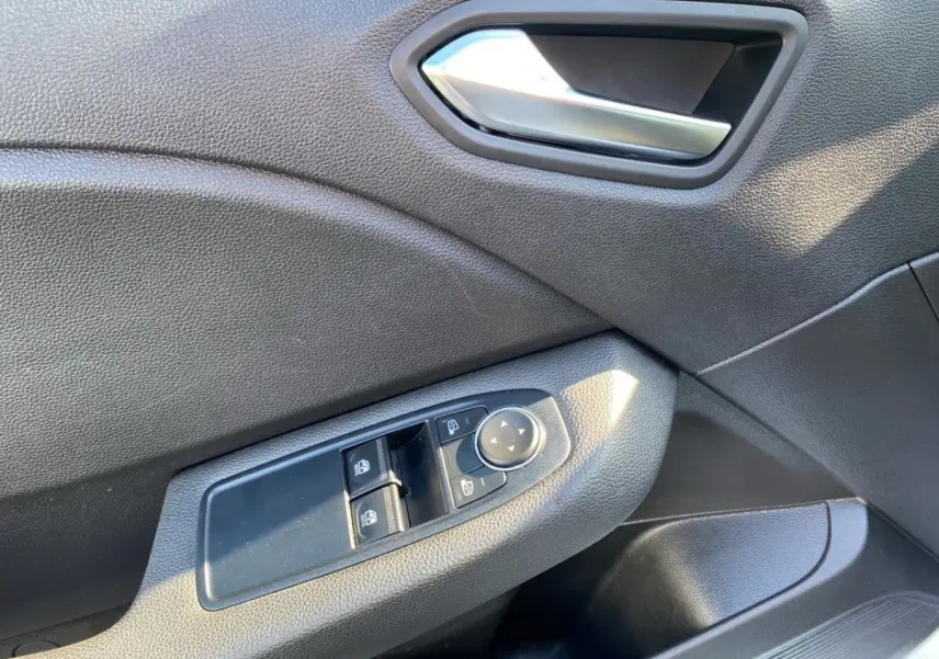 Détail de la commande des vitres et rétroviseurs sur la porte côté conducteur d'une Renault Clio blanche, 2021.