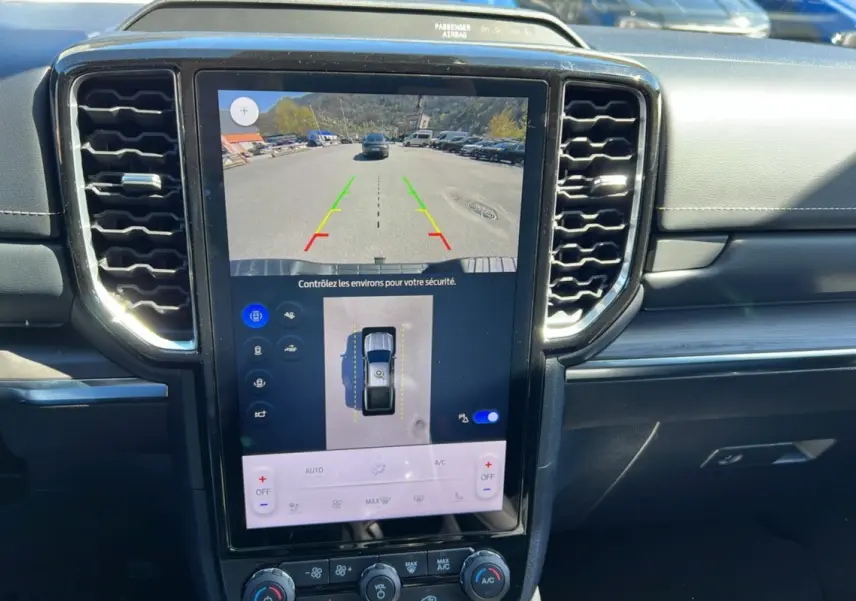 Vue rapprochée de la console centrale du Ford Ranger 2025 noir agate, écran tactile affichant la caméra de recul et les commandes climatisation.