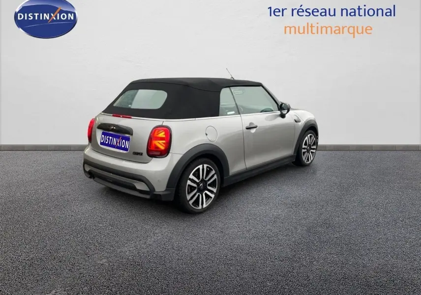 Vue 3/4 arrière droite d'une MINI Cabriolet F57 2023 Melting Silver Metal avec capote noire et feux arrière à motif Union Jack.