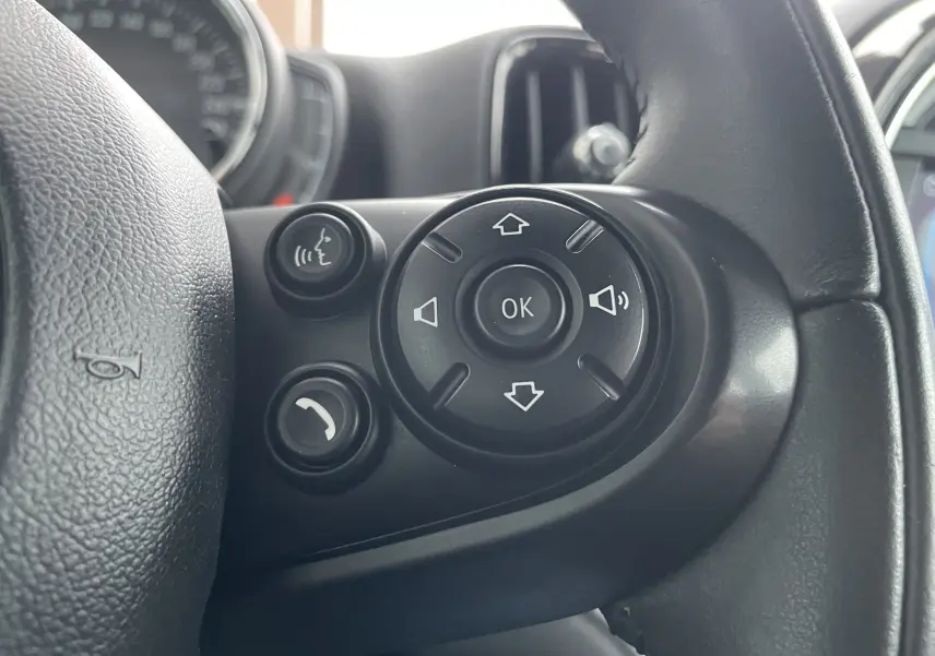 Gros plan sur les commandes vocales et de volume à droite du volant du MINI Countryman hybride bleu Island Metal de 2019.