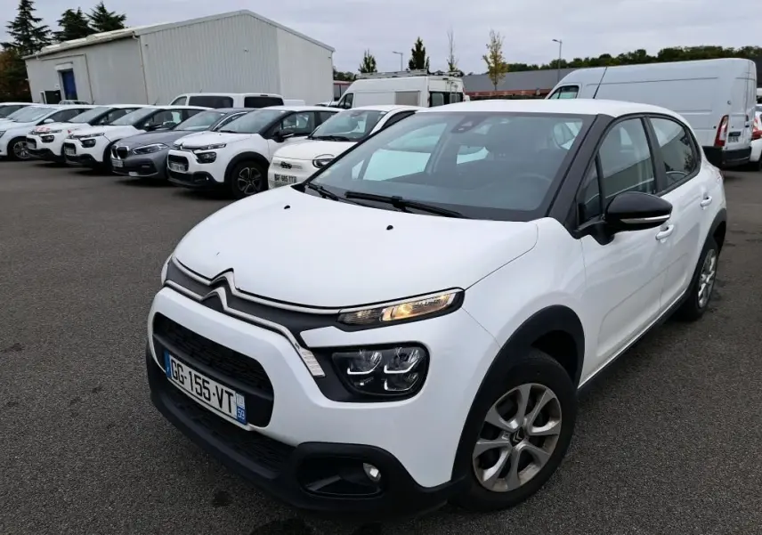 Citroën C3 Société blanche vue en 3/4 avant droit, avec calandre noire et feux LED allumés sur parking.
