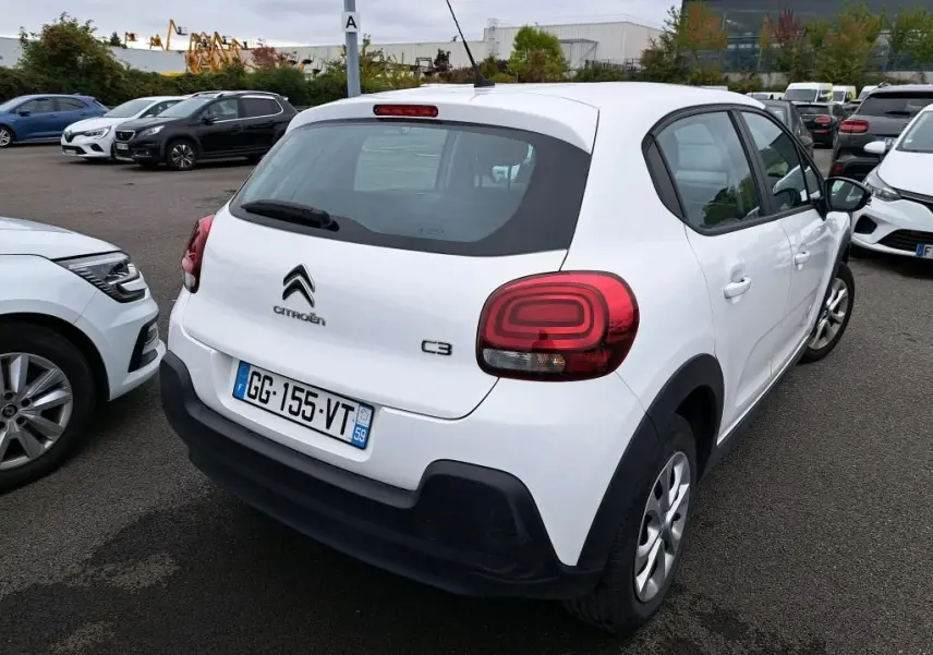 Vue 3/4 arrière droite d'une Citroën C3 Société blanche avec feux arrière distinctifs et pare-chocs noirs.