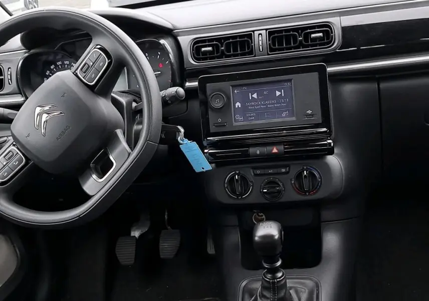 Vue intérieure côté conducteur du tableau de bord noir d'une Citroën C3 Société 2022, avec écran tactile et boîte manuelle.