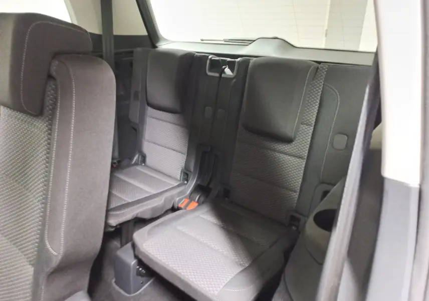 Vue intérieure sur la troisième rangée de sièges en tissu gris foncé du Volkswagen Touran 2025, version 7 places.