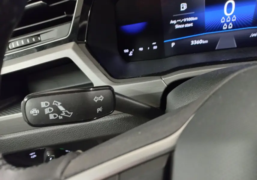 Détail du combiné d'instruments et du commodo gauche dans l'habitacle du Volkswagen Touran 2025 Gris Dauphin.