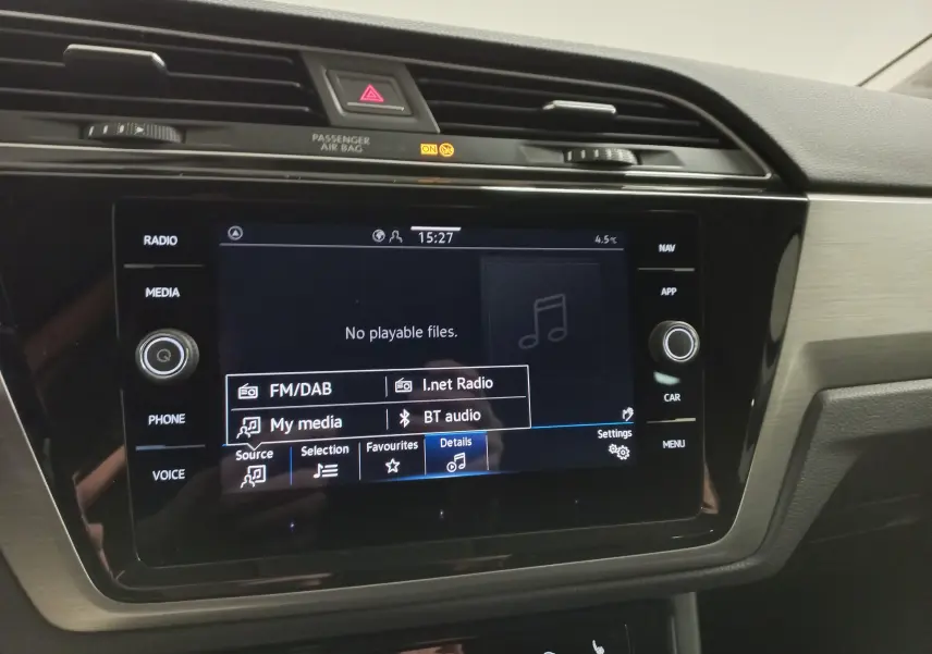 Gros plan sur l’écran tactile multimédia du Volkswagen Touran 2025, tableau de bord noir avec finitions gris métallisé.