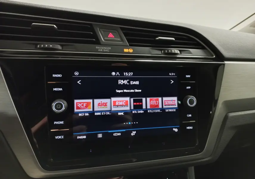 Vue rapprochée de l’écran multimédia tactile du Volkswagen Touran 2025 avec interface radio digitale affichée.