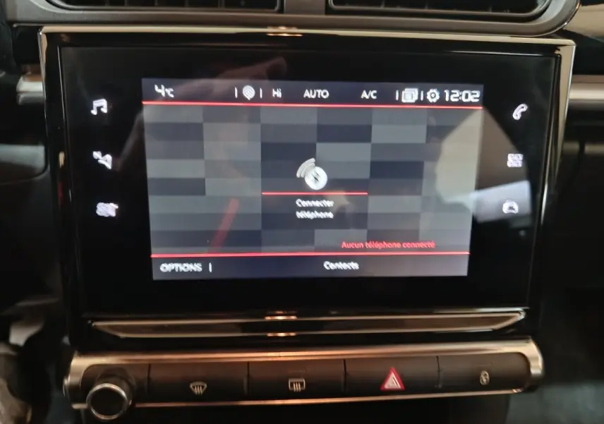 Écran tactile central allumé dans l'habitacle noir d'une Citroën C3 BlueHDi 100 BVM PLUS 2024.