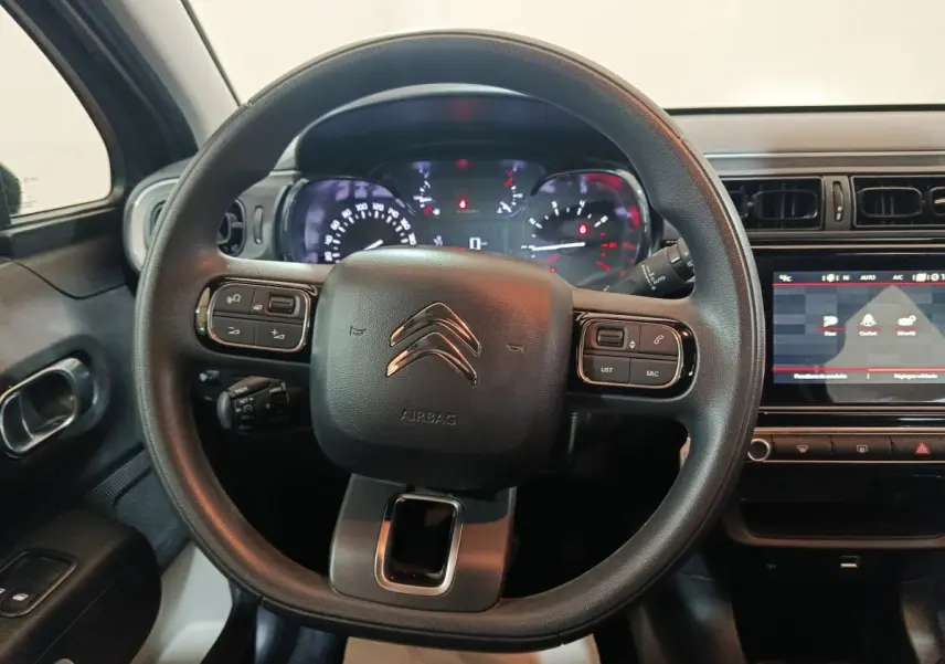 Vue intérieure centrée sur le volant noir multifonctions de la Citroën C3 2024 avec tableau de bord et écran tactile.