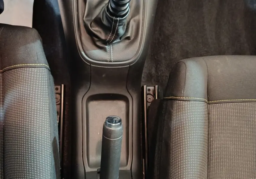 Vue plongeante sur la console centrale noire de la Citroën C3 2024, avec levier de vitesse manuel et frein à main.