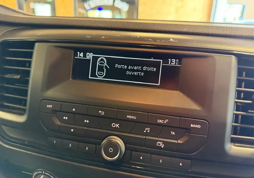 Vue rapprochée de l’écran central du tableau de bord du Citroën Jumpy gris affichant l’alerte porte avant droite ouverte.