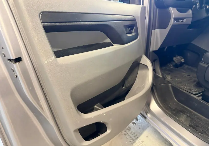 Détail de la porte avant gauche ouverte du Citroën Jumpy gris 2022, montrant la garniture intérieure et le seuil de porte.